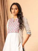 Handwoven light grey A-line panel top with handwork yoke featuring thread and mirror work, paired with blue printed pants