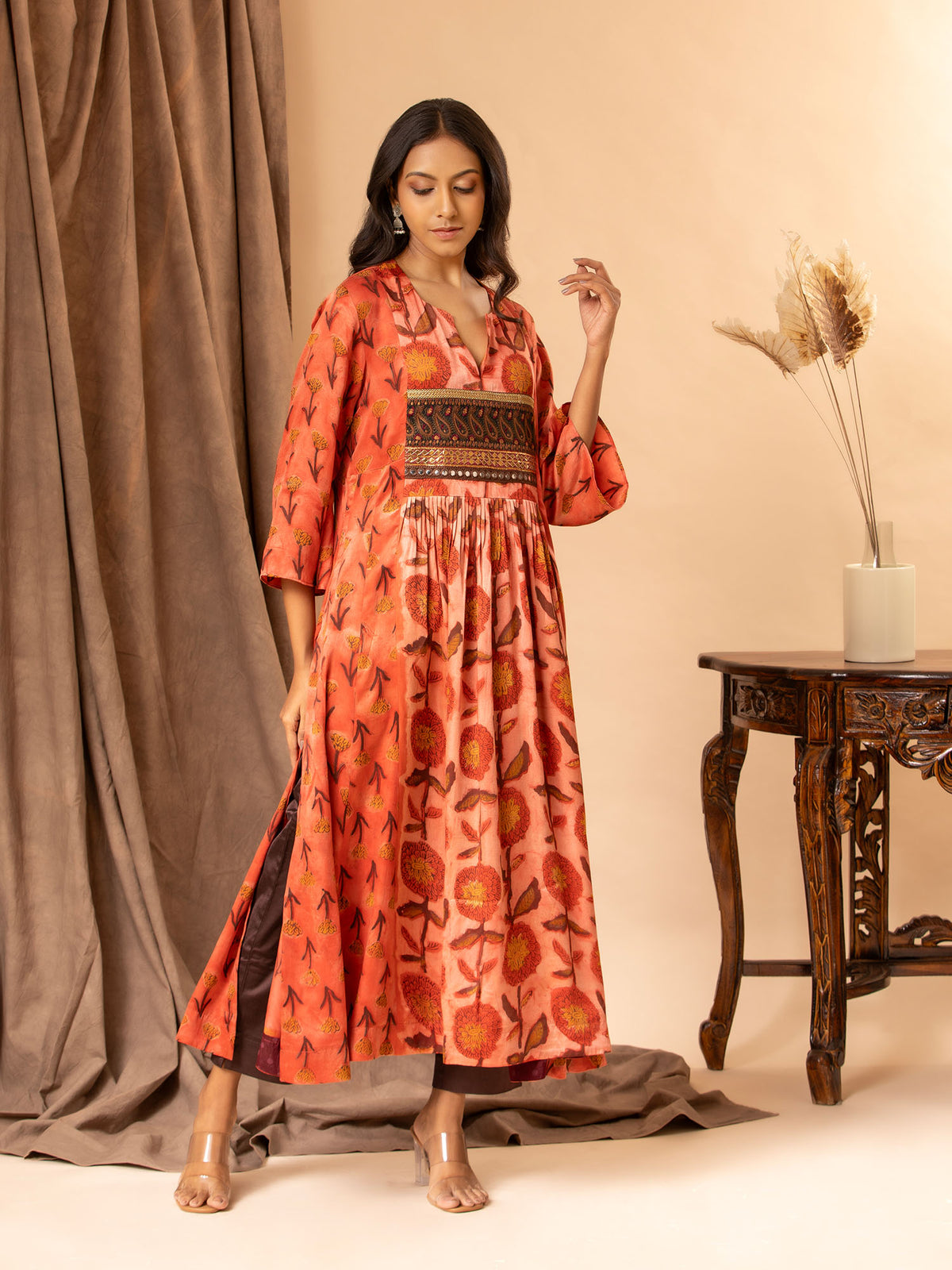 Mushroo printed silk gathered and panel top in burnt orange, with detailing on the yoke, paired with plain brown stretchable pants