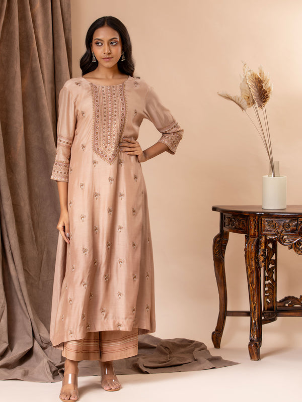 Pale brown muslin top with all over thread and mirror handwork, paired with pants.