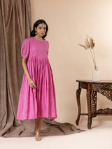 Vibrant pink mul cotton frock with tiny mirrors on the yoke, pleated detailing, puffed sleeves, and thread bhuttis