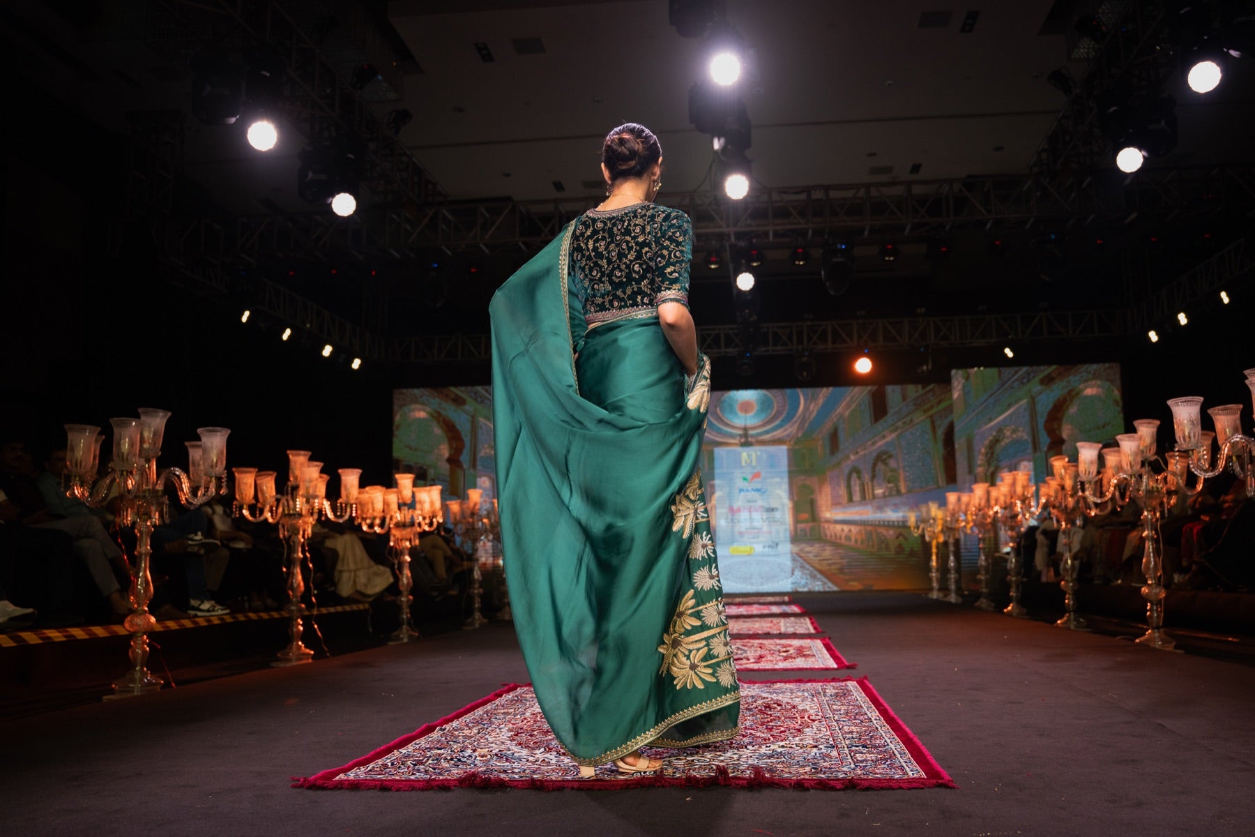 Model in an emerald saree, back view, walking the runway