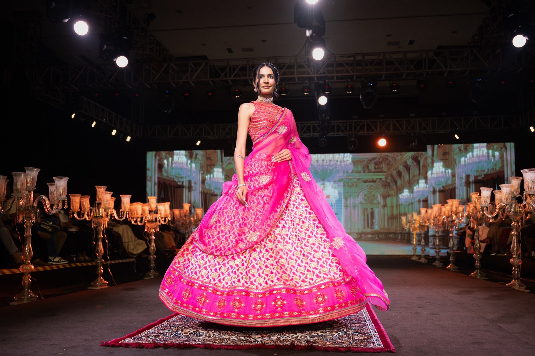 Model in a fuchsia lehenga with the skirt in full spread