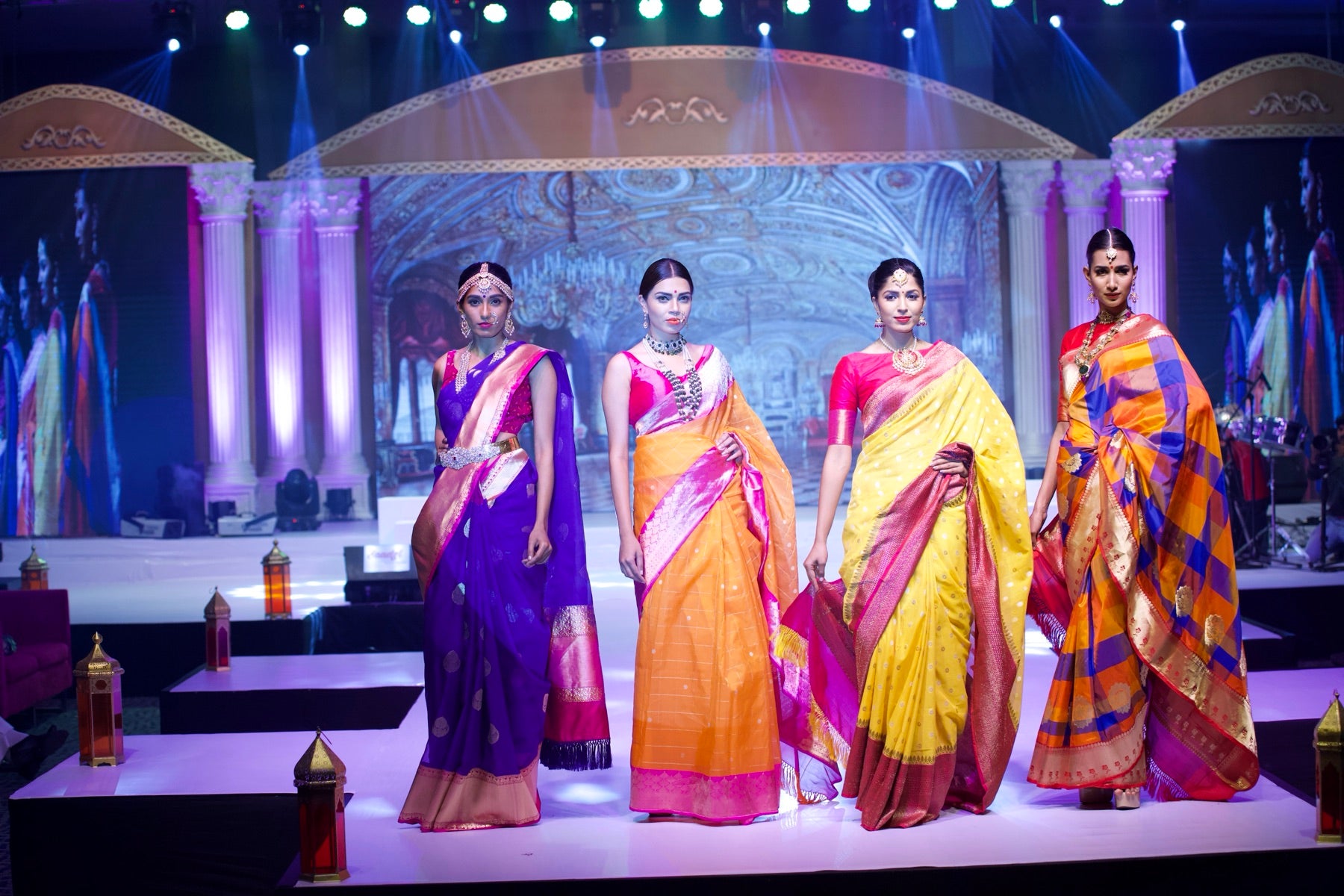 Four models in sarees walking the runway together