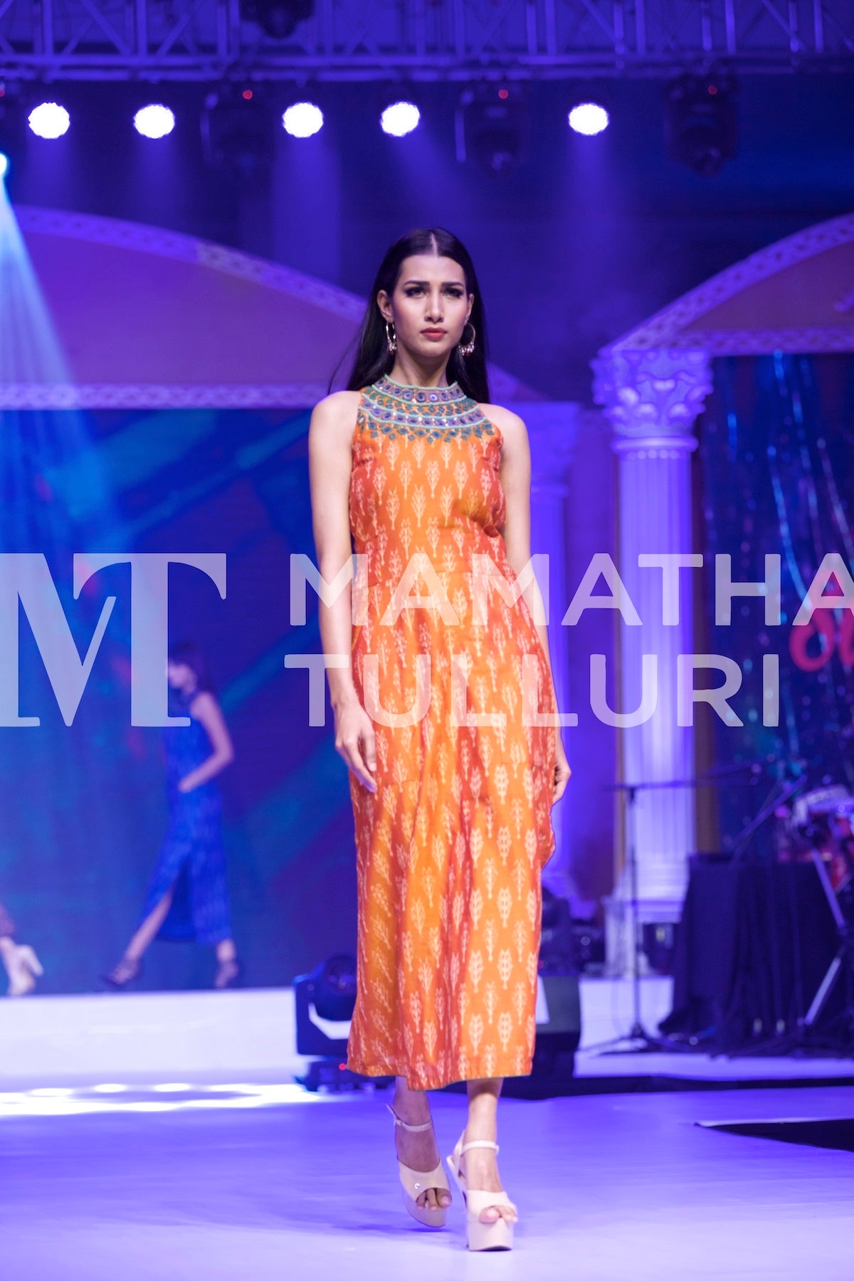 Model in a rust printed dress on the runway